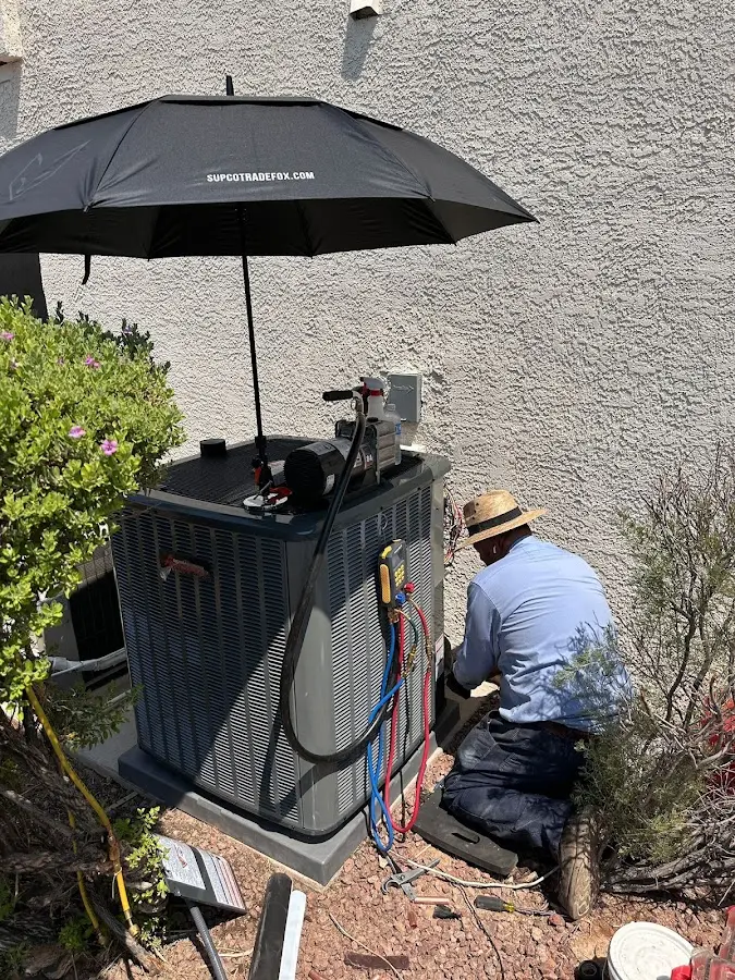 HVAC technician performing outdoor AC maintenance in Stratham