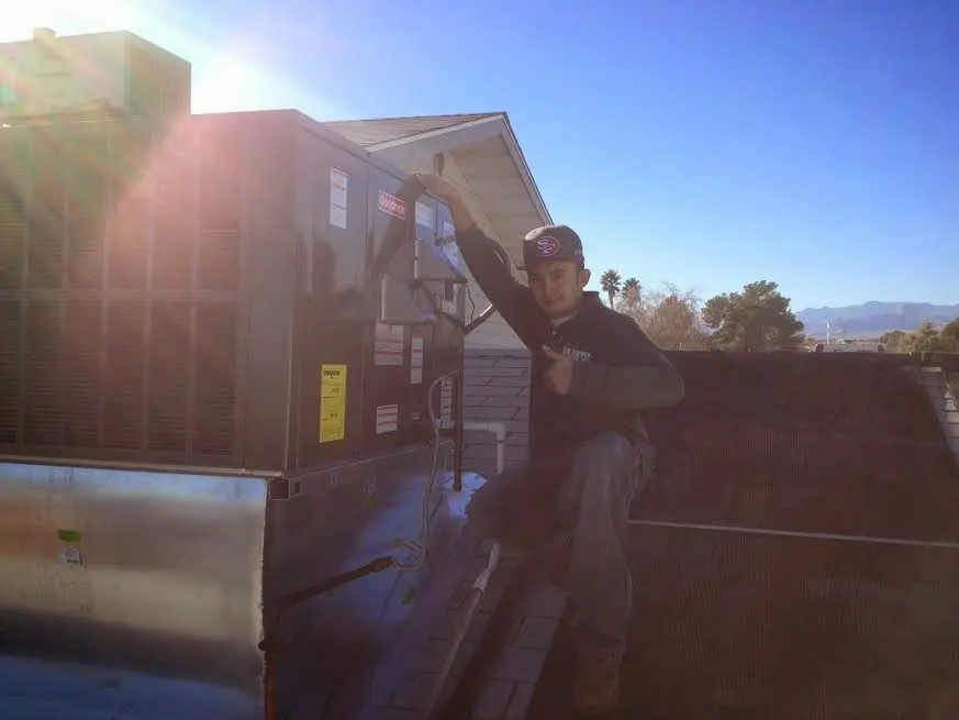 HVAC technician performing HVAC Inspection on a rooftop unit in Stratham